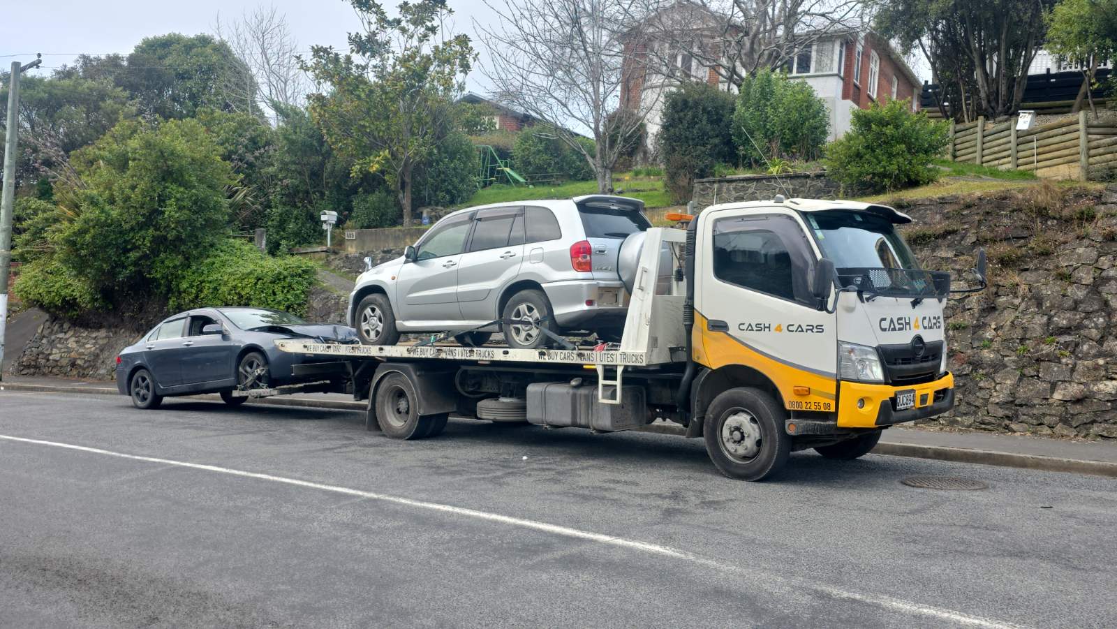 Cash4Cars truck towing an SUV and a sedan in Southland